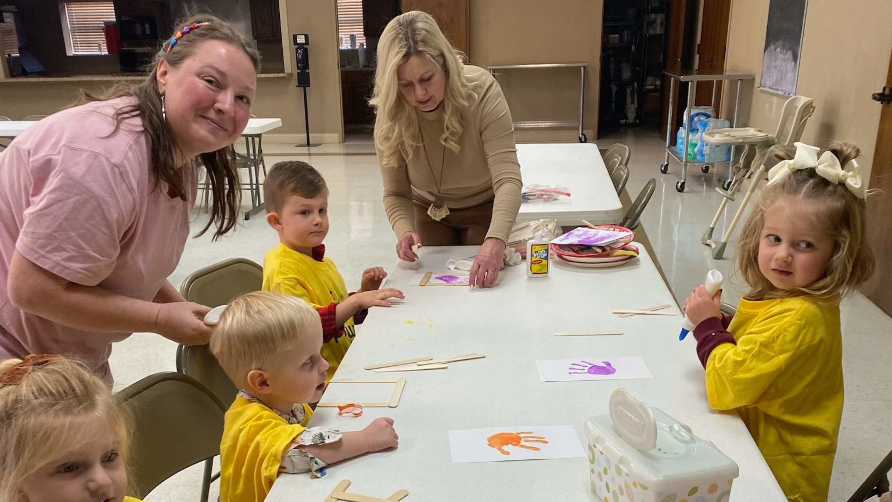 38 girl's left hand wrap around toddler while reading book during golden hour