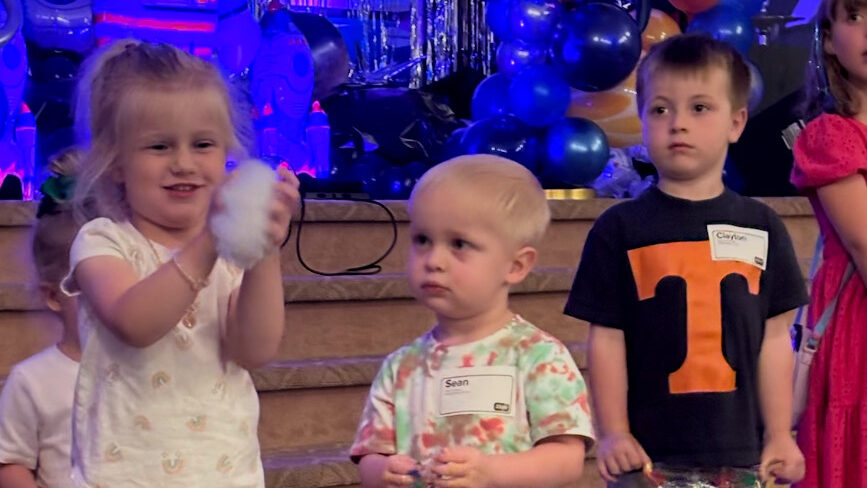 IMG_0538 girl's left hand wrap around toddler while reading book during golden hour